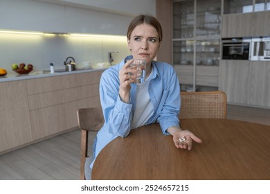 Frowning woman with emotional exhaustion seeks support by medication feels vulnerability at home. Pensive stressed female takes antidepressants, try to find relief from depression, burnout, distress - Powered by Shutterstock