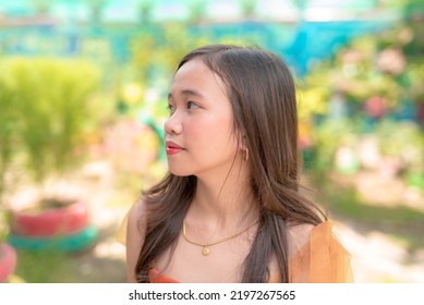 A Frowning Young Asian Girl Looks To The Side As She Thinks About How To Solve Her Problems.