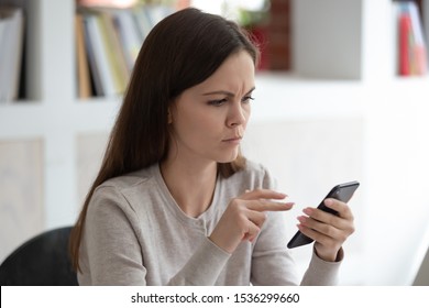 Frowny face young woman holding smartphone reading unpleasant message, bad news, mistake detection in written e-mail, slow internet, access account trouble signing in, malfunction, need repair concept - Powered by Shutterstock