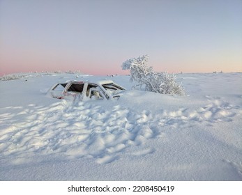 Frozen abandoned car covered under the snow in the north