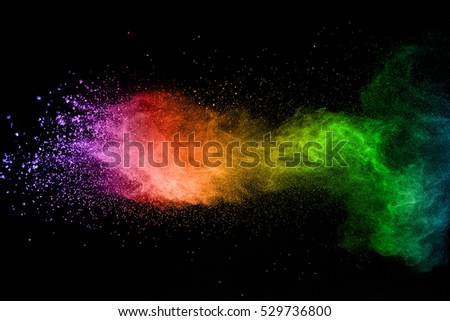 Frozen abstract movement of dust explosion colors on  black background. Stop the movement of multicolored powder on  dark background. Abstract colored powder on black background.
