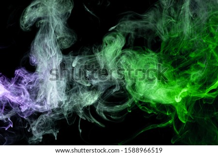 Frozen abstract movement of  explosion smoke multiple blue and greencolors on black background. Background from the smoke of vape
