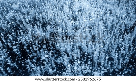 Frozen air bubbles inside transparent blue ice. Ice pattern and texture