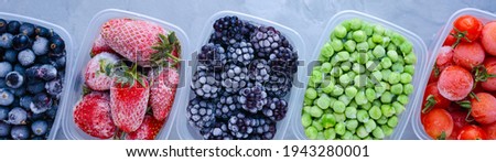 Frozen berries in boxes top view on gray background banner panoramic.