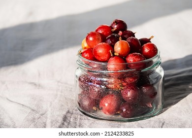 Frozen Berries In Glass Jar. Close Up Of Frozen Gooseberry.