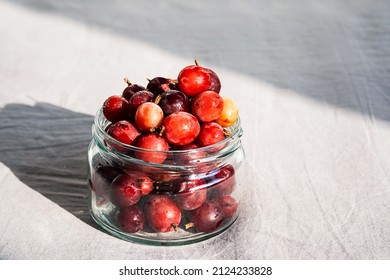 Frozen Berries In Glass Jar. Close Up Of Frozen Gooseberry.