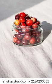 Frozen Berries In Glass Jar. Close Up Of Frozen Gooseberry.