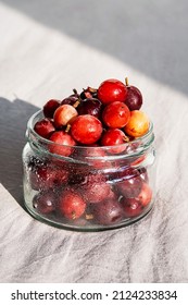 Frozen Berries In Glass Jar. Close Up Of Frozen Gooseberry.