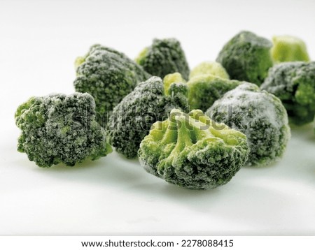 frozen broccoli florets on a white background, close up