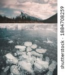 Frozen bubbles on the surface of Vermillion Lake in Banff, Alberta, Canada during winter. Mount Rundle is in the background. 