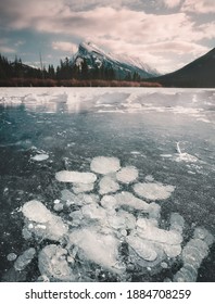 Frozen bubbles on the surface of Vermillion Lake in Banff, Alberta, Canada during winter. Mount Rundle is in the background.