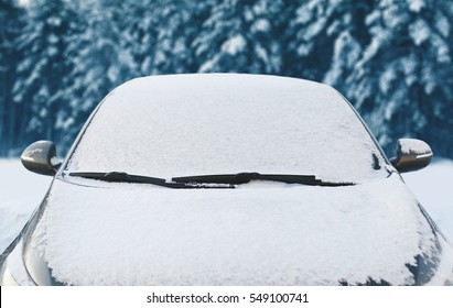 Frozen Car Covered Snow At Winter Day, View Front Window Windshield And Hood On Snowy Background