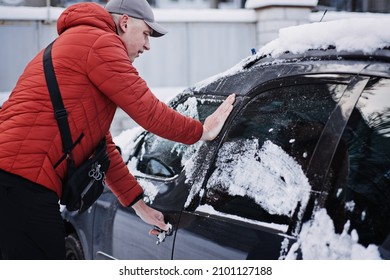 Frozen car door. Automobile car door or lock is frozen shut. Man driver trying to open frozen car door or lock