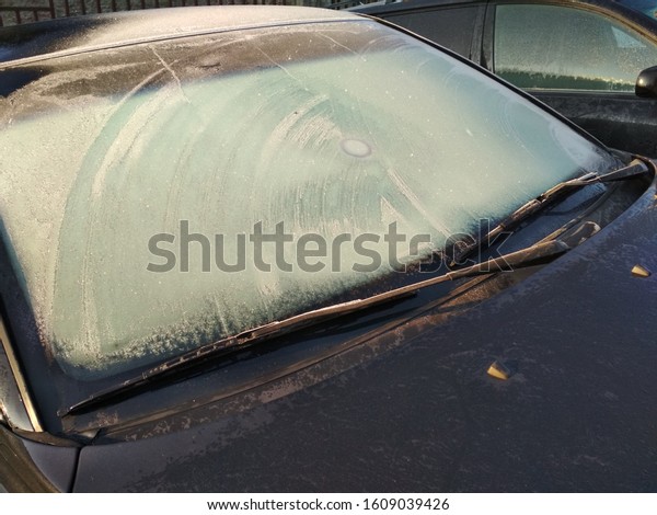 Frozen\
car front window in the winter - perspective\
view