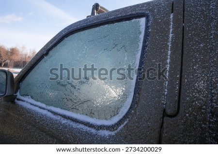 Frozen car side window covered with frost during cold winter weather