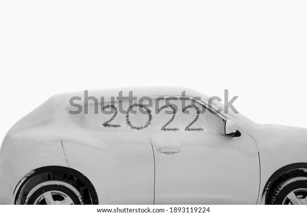 Frozen car side window in snow,  glass background.\
Snow covered frozen car covered with snow. Winter road. Danger of\
winter driving. Car snow removal. Dangerous traffic situation. 2022\
happy new year.