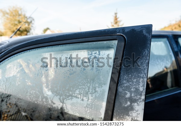Frozen car window covered\
with ice.