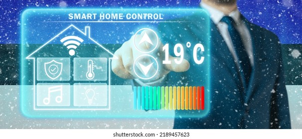 Frozen Citizen Of Estonia Adjusting Heating Temperature On A Virtual Screen Of Smart Home Controller, Winter Blizzard Background. Concept Of Forced Thrift Because Increased Price For Heating Home.