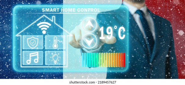 Frozen Citizen Of France Adjusting Heating Temperature On A Virtual Screen Of Smart Home Controller, Winter Blizzard Background. Concept Of Forced Thrift Because Increased Price For Heating Home.