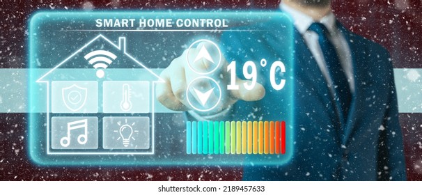 Frozen Citizen Of Latvia Adjusting Heating Temperature On A Virtual Screen Of Smart Home Controller, Winter Blizzard Background. Concept Of Forced Thrift Because Increased Price For Heating Home.