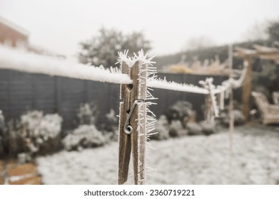 Frozen clothespeg with ice crystals on a washing line