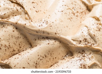 Frozen Coffee flavour gelato - full frame detail. Close up of a beige surface texture of Ice cream covered with brown coffee powder on the surface.