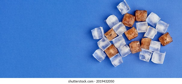 Frozen Cola In Cubes. Ice Lies On A Colored Background With A Place To Copy, Panoramic View, Advertising Taste. Top View.