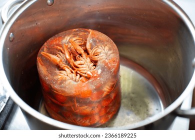 Frozen crayfish are thawed in a saucepan.