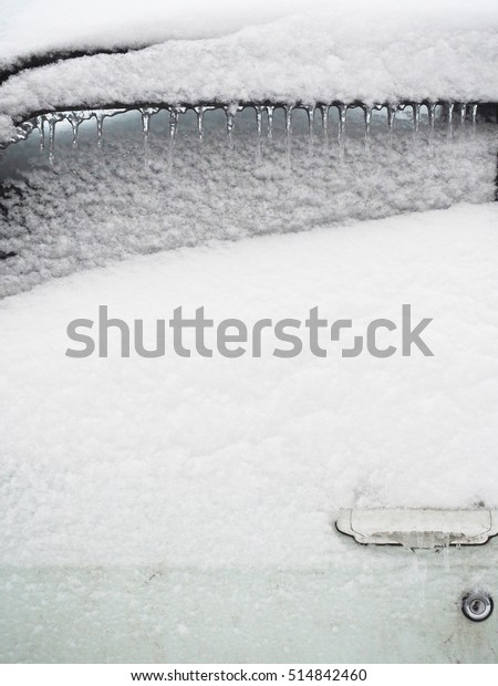 Frozen door handle of a car, frozen of the car with\
icicles, ice and snow