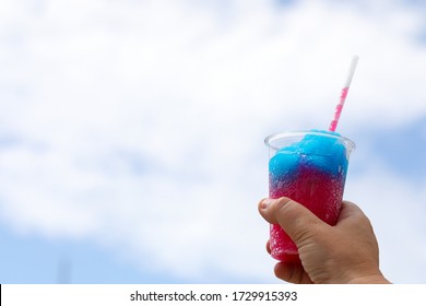 A frozen drink or slushy held up to the sky. 
