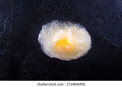 Frozen Egg Over On Black Background. Top View. Copy Space