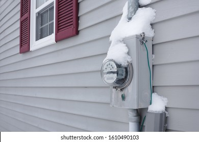 Frozen electrical utility meter on house  exterior siding.