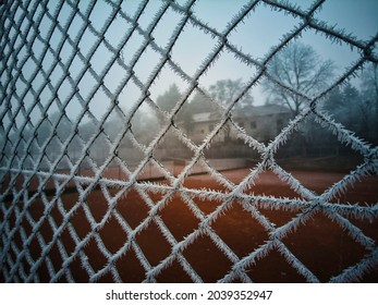 frozen fence with frost next to a tennis court on a very cold winter morning