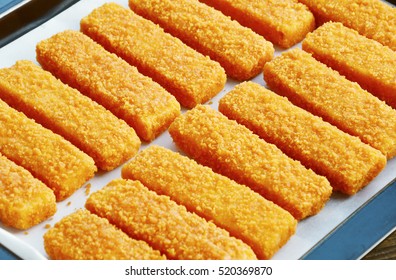 Frozen Fish Sticks In Tray For Oven On Wooden Background.
Convenience Food.