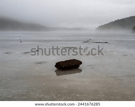 Frozen and foggy lake in Sweden. Mysterious landscape