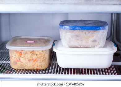 Frozen food in a container in the freezer. Refrigerator with frozen food. Ready meal