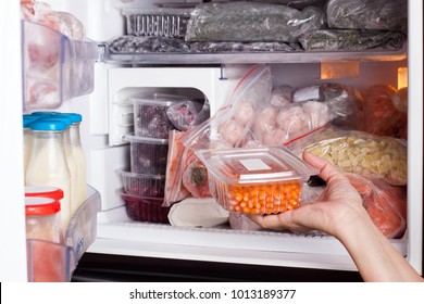 Frozen food in the refrigerator. Vegetables on the freezer shelves.