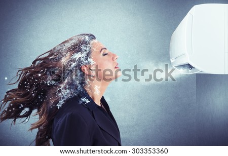Frozen girl under a powerful air conditioner