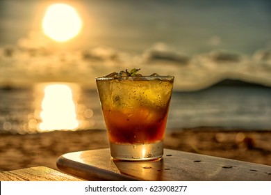 The Frozen Glass Of Mojito Drinks On The Beach At Sunset With Blur Background.