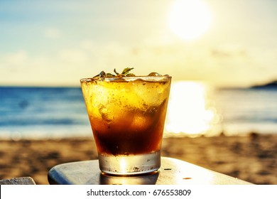 The Frozen Glass Of Mojito Drinks On The Beach At Sunset With Blur Background.