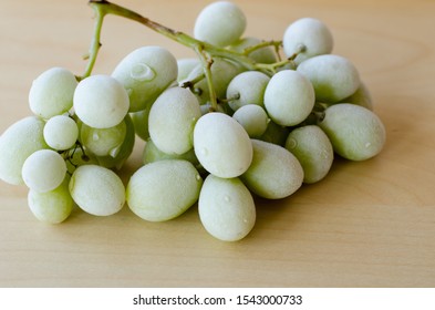 Frozen Green Grapes On A Wooden Table