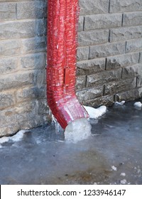 Frozen Gutter, Downspout. Gutter Pipe, Downspouts, House Foundation Wall Sometimes Freeze Into Solid Blocks Of Ice. Bad Rain Gutter Cleaning.