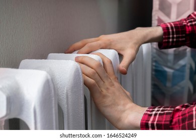 Frozen Hands Touch A Heating Battery At Home During Winter Season