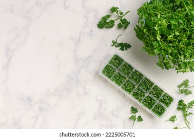 Frozen herbs for cooking. Fresh organic parsley and parsley ice cubes on a marble background. The concept of frozen food. Selective focus, top view and copy space - Powered by Shutterstock