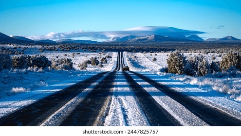 Frozen highway from Grand Canyon National Park to Williams Arizona on a cold sunny winter morning. Snow covered lanes in wide american landscape with oncoming truck. Symmetric panorama of wide scenery - Powered by Shutterstock