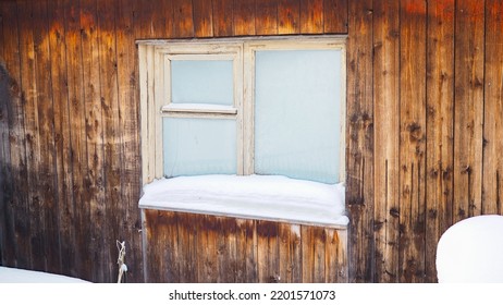 Frozen hut window in winter. Frost on glass. Snow and snowdrifts. Wooden wall of the house. Bucolic illustration on winter theme - Shutterstock ID 2201571073