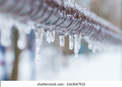 frozen icicles after rain on the pipe - Shutterstock ID 1563047923