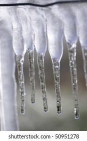 Frozen icicles that look like cotton swabs hanging for a wire.