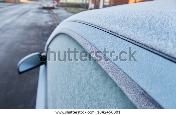 A frozen icy cold textured car in winter on a freezing\
morning, frozen windscreen. frozen solid in the windy freeze\
environment. frosty windows and black ice on the road.             \
           
