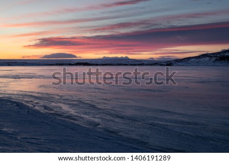 Frozen lake Ljosavatn, known as mirror lake during winter sunrise, Iceland